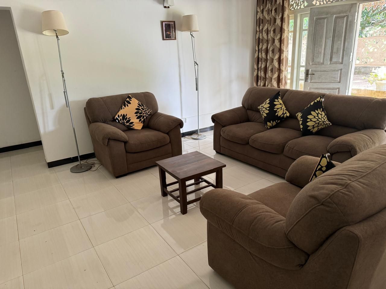 A living room with two sofas, a coffee table, and two floor lamps.