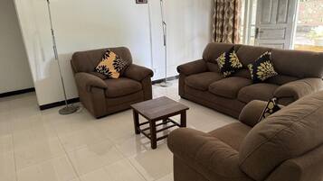 A living room with two sofas, a coffee table, and two floor lamps.