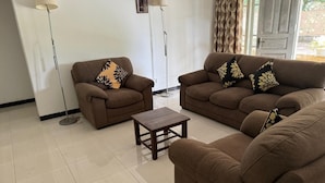 A living room with two sofas, a coffee table, and two floor lamps. - Dambulla Hills Resort (Dambulla)