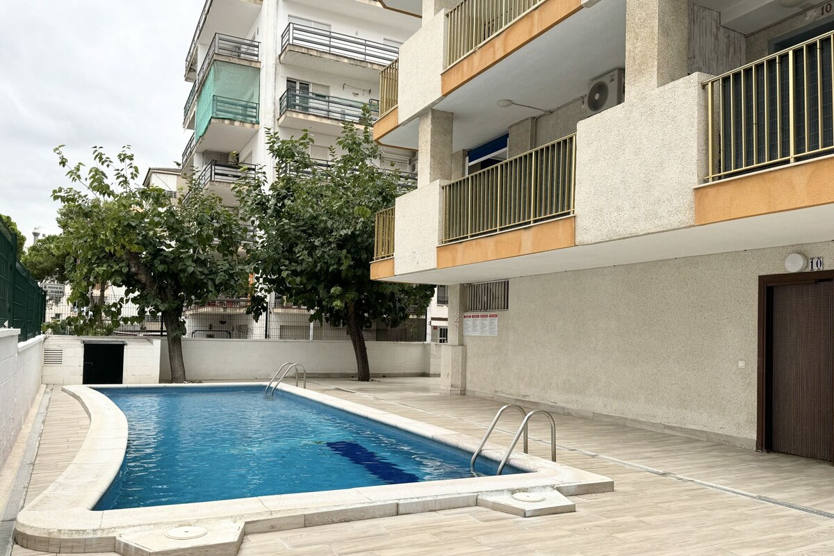 Una piscina al aire libre con borde curvo, rodeada por una solana empavedada.
