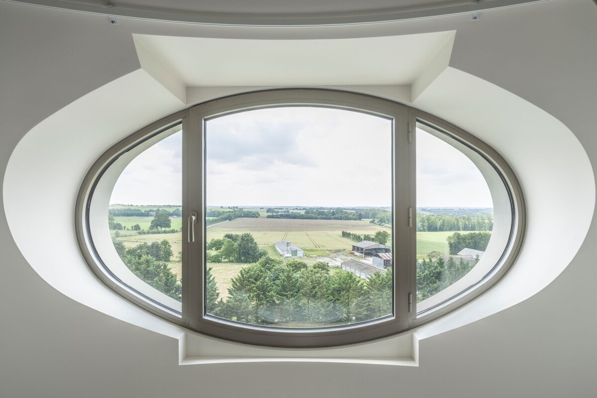 A skylight with a panoramic view of a rural landscape.