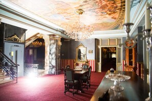 A grand room with a red carpet, a chandelier, and ornate furniture. - Nf Palace Old City Bucharest (Bucharest)