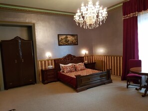 A bedroom with a large bed, a wardrobe, a chandelier, and a painting on the wall. - Nf Palace Old City Bucharest (Bucharest)
