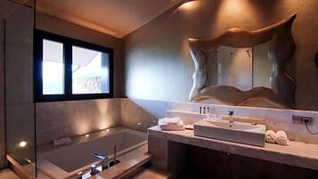A modern bathroom with a large bathtub, a vanity with a mirror, and a view of the outdoors.