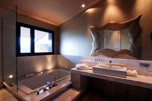 A modern bathroom with a large bathtub, a vanity with a mirror, and a view of the outdoors. - Dolcet L Hotel (Alàs i Cerc)