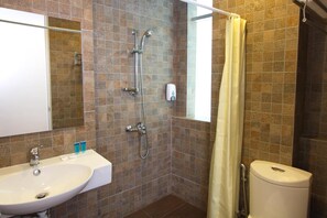 A bathroom with a sink, mirror, shower, and toilet. - Molek Garden Hotel (Johor Bahru)