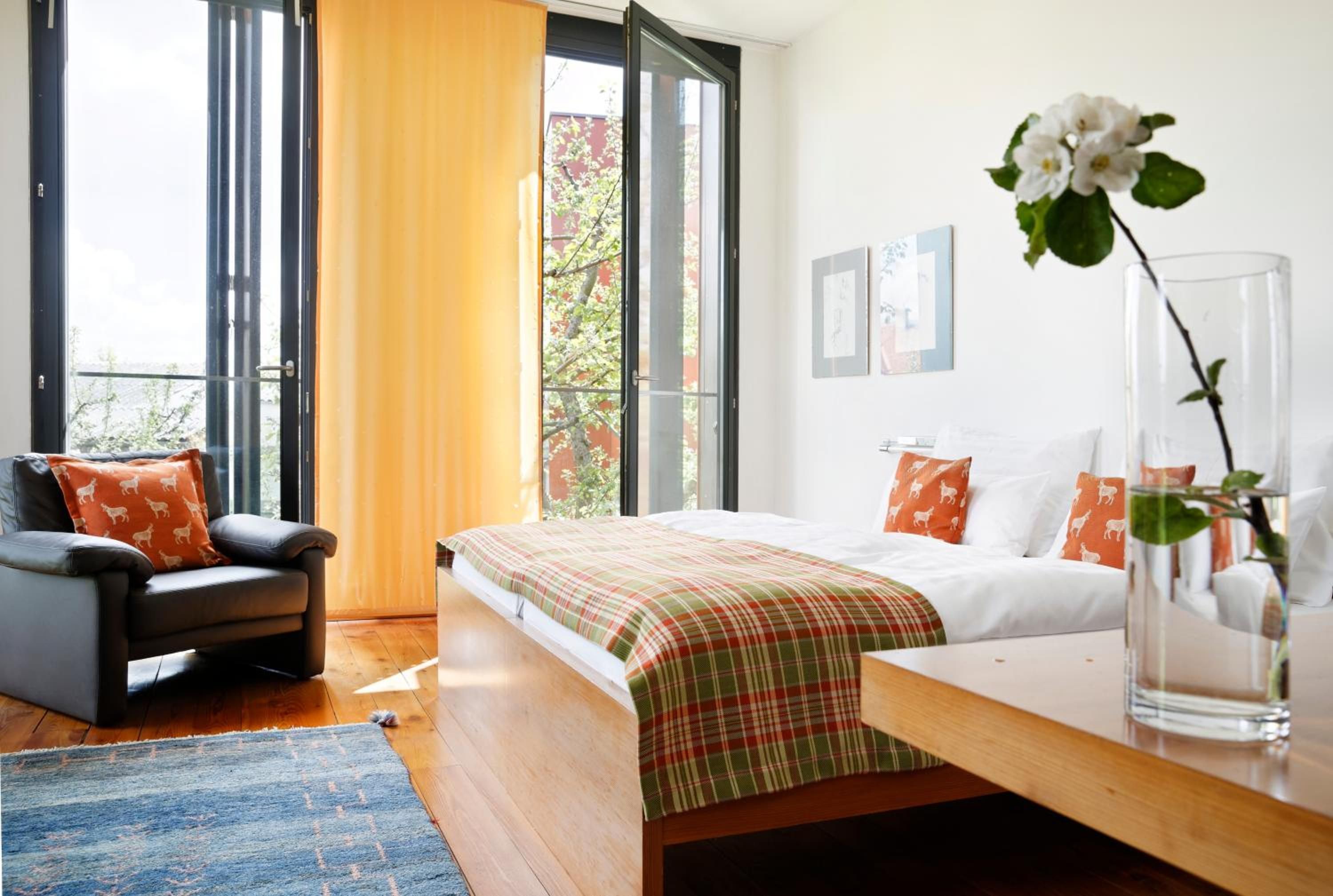 A hotel room with a bed, a desk, a chair, and a large window.