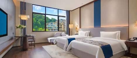 Habitación de hotel moderna con una cama grande, un escritorio y un ventanal con vista a la ciudad.