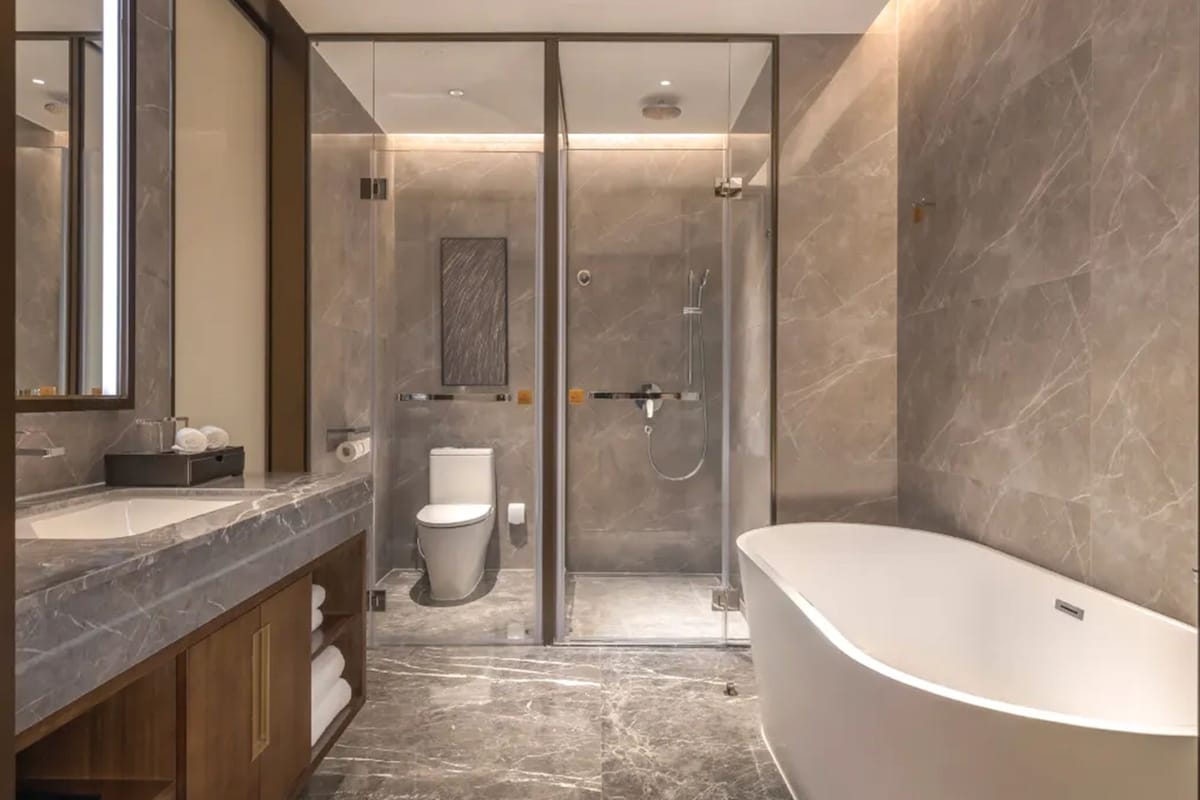 A modern bathroom with a freestanding bathtub, a glass-enclosed shower, and a toilet.
