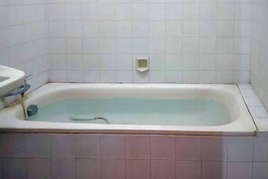 Un baño con bañera, lavabo e inodoro.