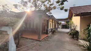 Un barrio residencial con una casa que tiene un porche, un garaje y un pequeño jardín.