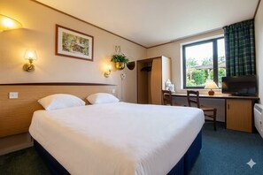 A hotel room with a bed, desk, television, and a window with curtains. - The Galleon Hull (Hull)