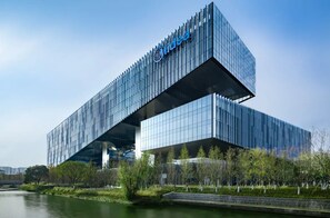 Un bâtiment moderne, doté d’un logo bien visible, d’un toit plat et d’une façade en verre réfléchissant.