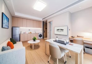 A modern hotel room with a kitchenette, a dining area, and a seating area. - Shanghai Also Hotel (Shanghai)