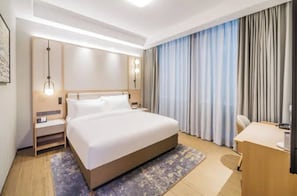 A hotel room with a large bed, bedside tables, a desk, and a chair. - Shanghai Also Hotel (Shanghai)