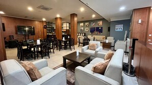 A spacious living area with a dining set, sofas, and a television. - Mahakam24 Residence (Jakarta)