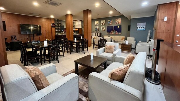 A spacious living area with a dining set, sofas, and a television. - Mahakam24 Residence (Jakarta)
