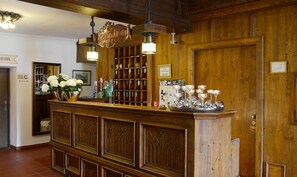A reception area with a wooden counter, a sign indicating 'Reception,' and a wall-mounted display case with keys. - Hotel Hafnerwirt (Hallein)