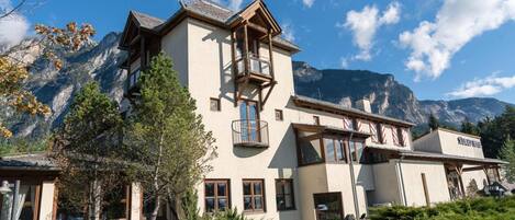A mountain lodge with a balcony, a mountain view, and a sign reading 'Ski Resort'.