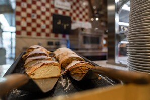 A pastry display with a checkered wall and a sign in the background. - Hotel Restaurant Sv Drast Dreilv Ndereck (Arnoldstein)