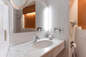 A bathroom with a marble sink, a mirror, a towel dispenser, and a telephone. - Hotel Restaurant Sv Drast Dreilv Ndereck (Arnoldstein)