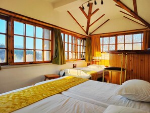 A room with two beds, wooden beams on the ceiling, large windows, and a view of the outdoors. - Park Hotel Amfora (Sofia)
