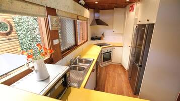 A compact kitchen with a sink, stove, and refrigerator.