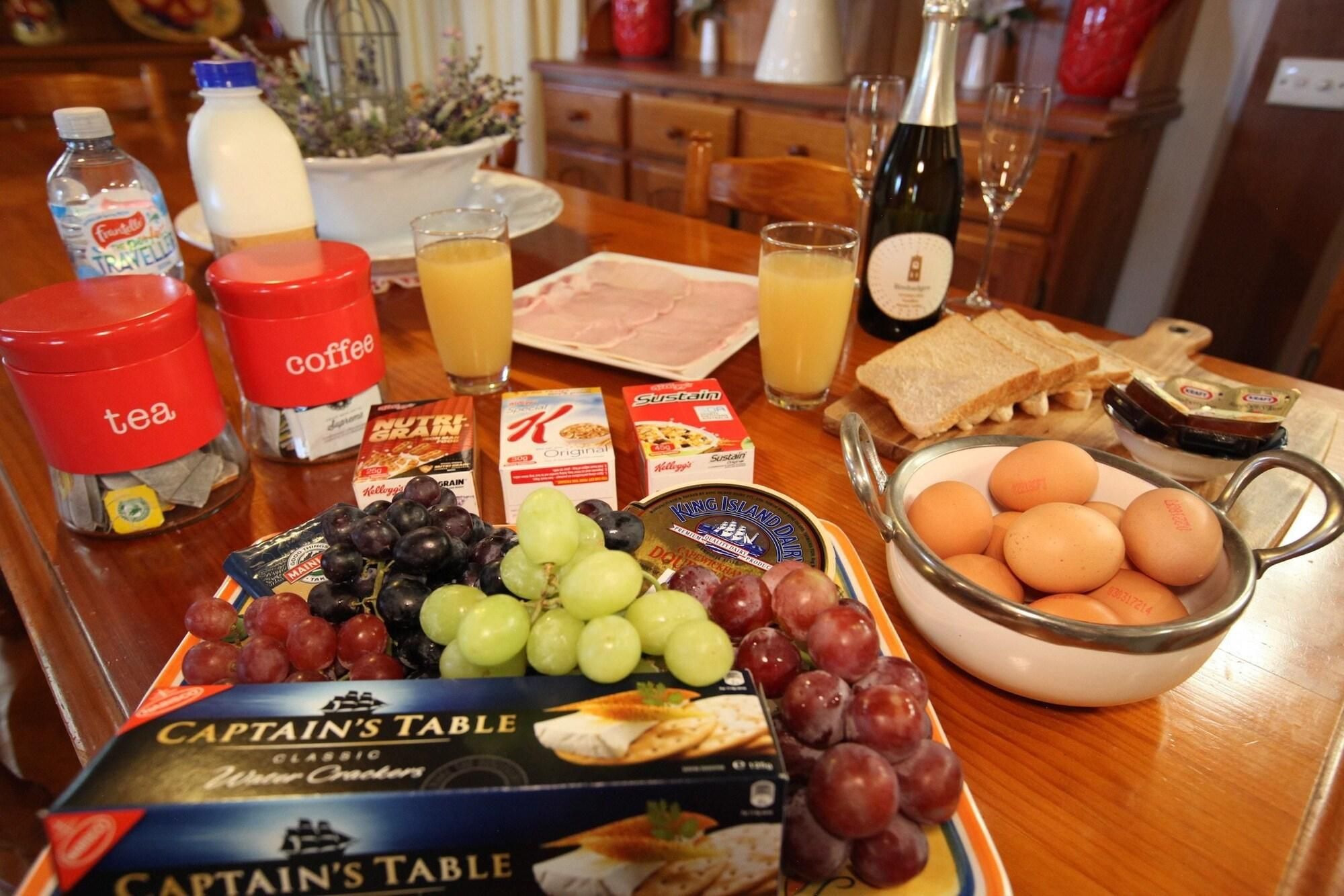 A breakfast table with various food items, including bread, eggs, and a box of Captain's Table cheese crackers.