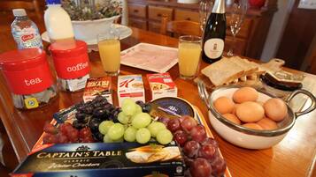 A breakfast table with various food items, including bread, eggs, and a box of Captain's Table cheese crackers.