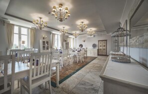 A spacious dining area with white furniture, multiple chandeliers, and a decorative birdcage. - Orient Palace (Kobierzyce)