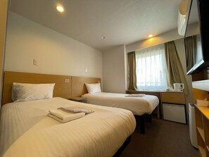 A hotel room with two beds, a desk, a television, and a window with curtains. - Hotel Passage 2 (Aomori)