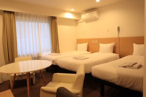 A hotel room with two beds, a round table, and a chair. - Hotel Passage 2 (Aomori)