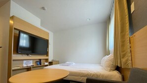 A hotel room with a bed, a TV, a small table, and a sofa. - Hotel Passage 2 (Aomori)