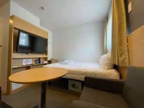 A hotel room with a bed, a TV, a small table, and a sofa. - Hotel Passage 2 (Aomori)