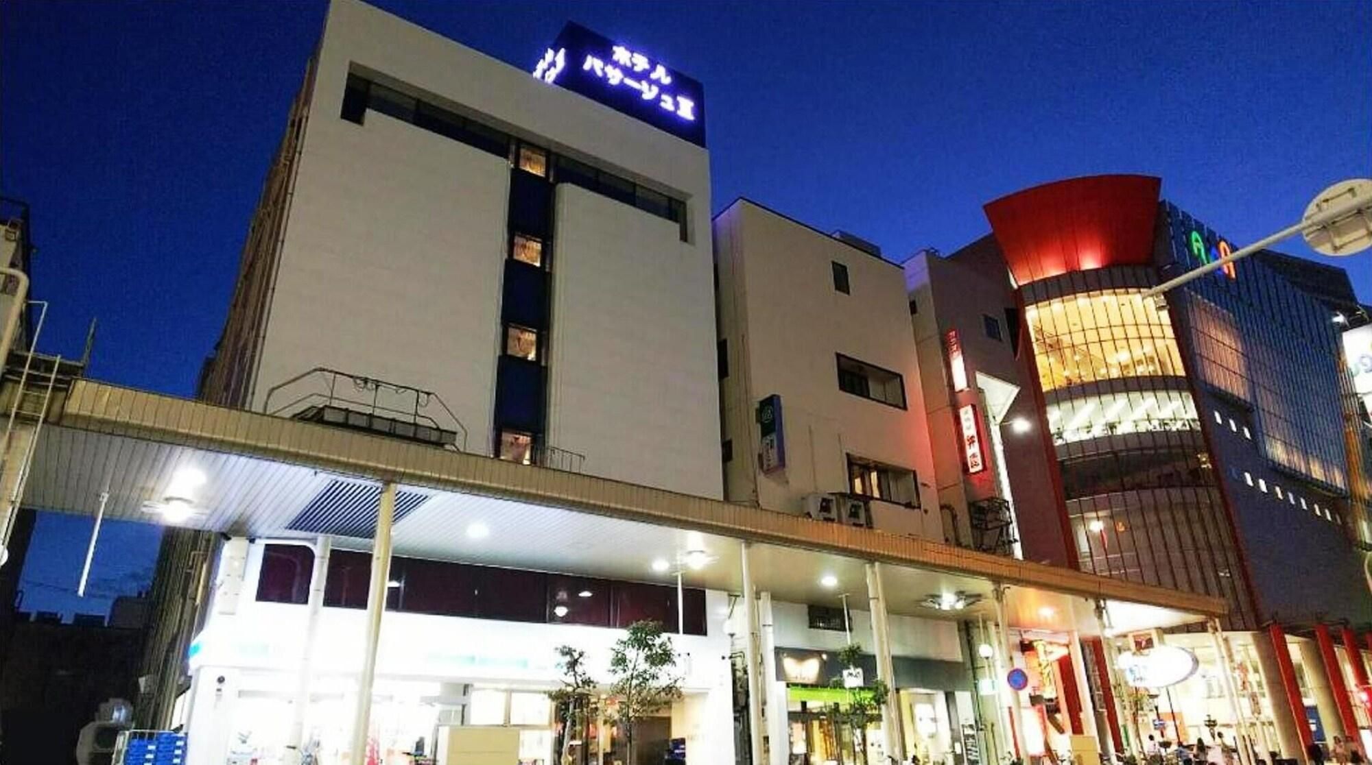 Un edificio moderno con un cartel llamativo, un acceso cubierto y una esquina bien iluminada.
