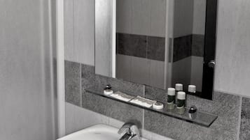 A bathroom with a white sink, a mirror, and a towel rack.