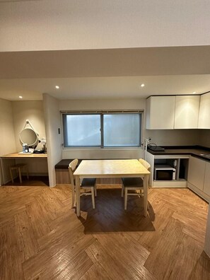 Una cocina funcional con mesa de comedor, microondas y ventana.