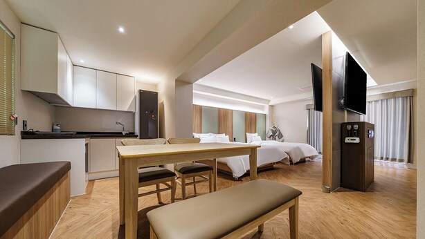 A modern hotel room with a kitchenette, a dining area, a bed, and a TV. - Brown Dot Hotel Eurwangri (Incheon)