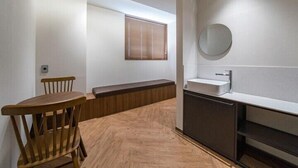 A modern bathroom with a sink, mirror, and wooden bench. - Brown Dot Hotel Eurwangri (Incheon)