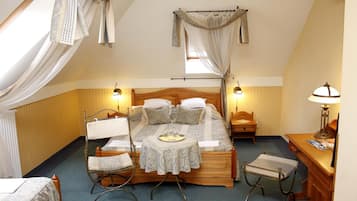 A bedroom with a wooden bed, two bedside tables, a chair, and a desk with a lamp.