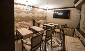 A room with a sofa, chairs, a TV, and a patterned wall. - Hotel Diamond (Kazanlak)