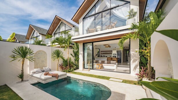 A modern house with a swimming pool, a glass-enclosed living area, and lush greenery. - VIlla Ezra Azul (Uluwatu)