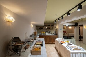 A buffet setup with various food items and a grill station. - Hotel Ntinas (Trikala)