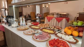 Un bufé con una variedad de alimentos, incluyendo carnes, quesos, frutas y verduras.