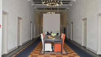 Ein Hotelkonferenzraum mit einem langen Tisch, Stühlen, einer Kristallleuchtre und einem Schachbrettfußboden.