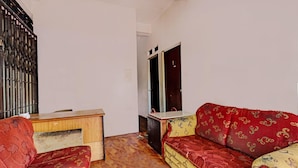 A room with a wooden desk, a sofa, and a mirror. - Spot On 92167 Jodoh Stay Syariah (Batam)