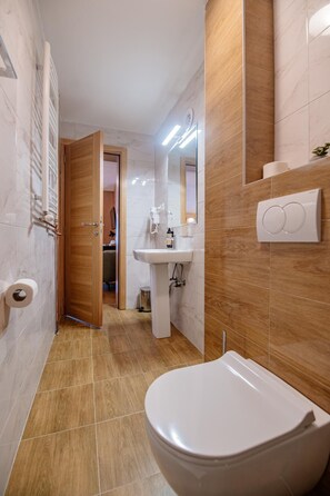 Un baño con inodoro, lavamanos y bidé.