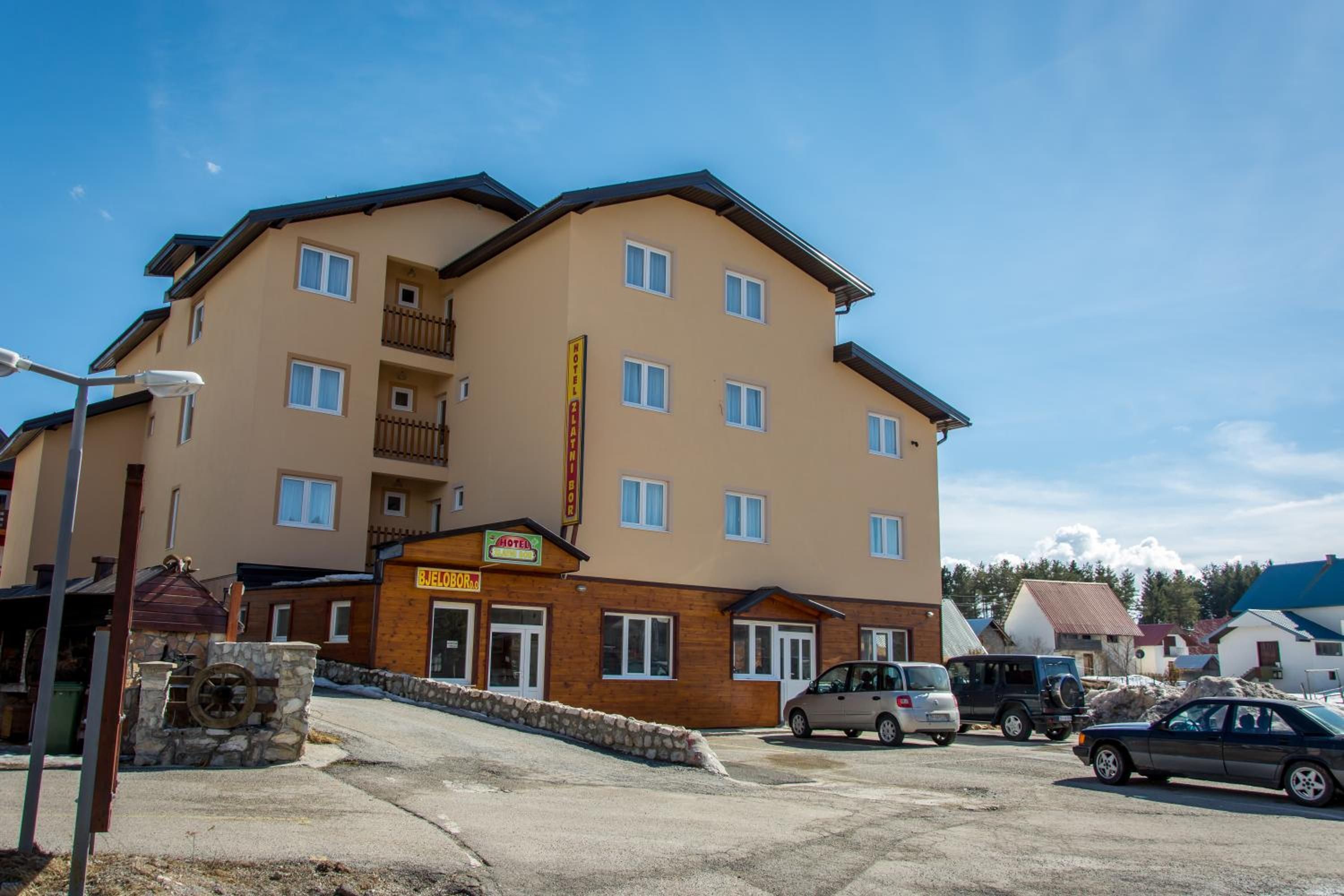 A multi-story hotel with a flat roof, balconies, and a sign indicating it is a hotel.