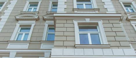 Un edificio de varios pisos con fachada simétrica, con ventanas y balcones distribuidos uniformemente.