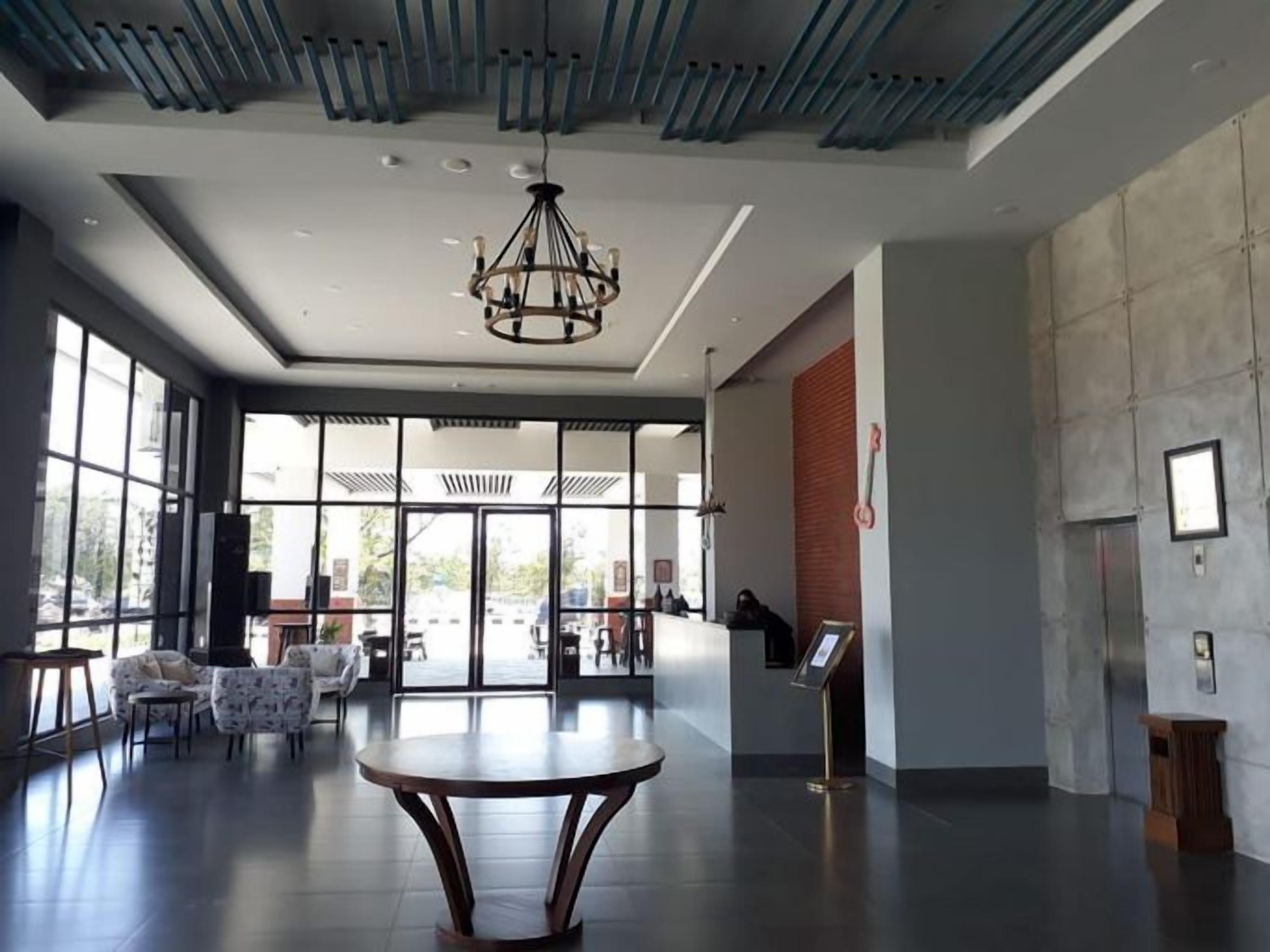 Un hall d’entrée spacieux avec une table centrale, un espace salon et un comptoir d’accueil.